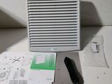 un climatiseur blanc posé sur une table à côté de quelques feuilles de papier