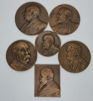 five bronze medallions of men with faces of different ages