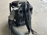 a backpack with a hose attached to it sitting on the ground