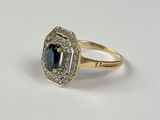 gros plan d'une bague avec un saphir et des diamants