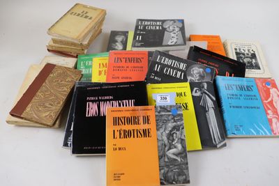 Plusieurs livres sont empilés sur une table devant un fond blanc.