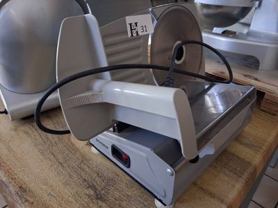 a meat slicer sitting on a table in a kitchen