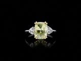 a yellow and white diamond ring on a black surface