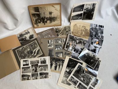 plusieurs vieilles photos en noir et blanc représentant des personnes et des véhicules, posées sur une table