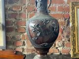 un vase posé sur une table à côté d'un tableau