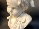 a small statue of a boy with a hat on his head