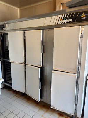 several refrigerators are lined up in a kitchen with white tile flooring