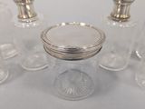 four clear glass jars with silver lids and a silver lid