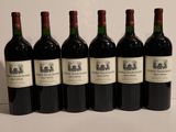 six bottles of wine are lined up on a table