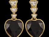 a pair of black and white diamond heart shaped earrings