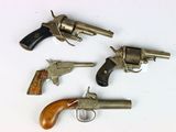 three old revolvers sitting on top of a table next to each other