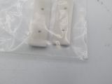 two pieces of plastic sitting on a white surface