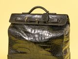 porte-documents en cuir d'alligator noir sur fond jaune, avec un espace réservé au texte