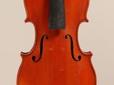 un vieux violon posé sur une surface blanche