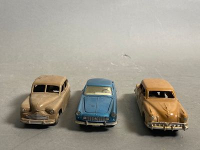 four toy cars are lined up in a row on a gray surface