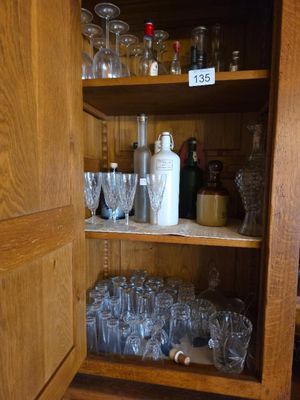 une armoire en bois sur laquelle sont posés de nombreux verres et bouteilles