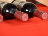 three bottles of wine sitting on a red table