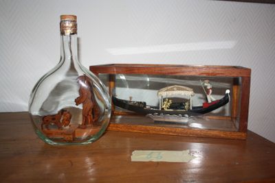 a glass bottle with a ship inside of it on a table