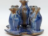 three blue vases sitting on a tray on a white surface