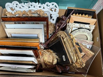 a cardboard box filled with assorted framed and unframed items