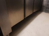 un sol sale dans une cuisine équipée d'appareils électroménagers en inox