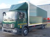 a large green truck parked in front of a building