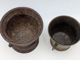 two metal cups sitting next to each other on a table
