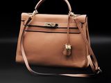 a brown leather handbag on a black background