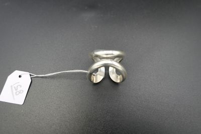 une bague en argent attachée à un cordon, avec une étiquette accrochée dessus