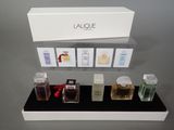 a display of various perfumes on a black shelf