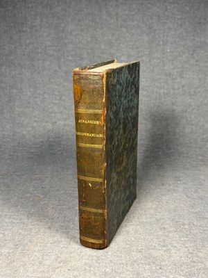 an old book sitting on top of a table next to a gray background