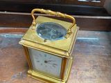 a small gold clock sitting on a wooden table