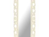 un grand miroir blanc dont le cadre est orné d'un motif floral