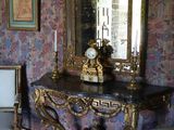 a table with a mirror and a chair in a room