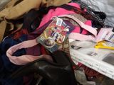 a pile of clothes and shoes on a bed
