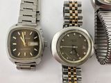 three watches sitting next to each other on a white surface