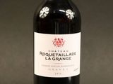 une bouteille de vin rouge avec un bouchon rouge sur fond noir