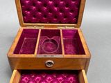 an open wooden box with a purple velvet lining inside
