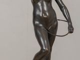 statue of a woman holding a tennis racquet on a wooden table