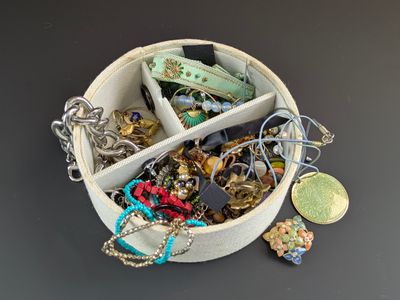 une boîte blanche remplie de bijoux variés, posée sur une table