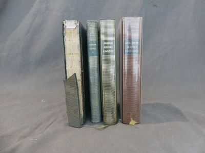 Plusieurs livres sont empilés les uns sur les autres sur un fond gris.