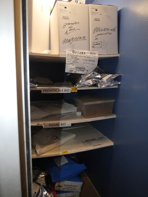un placard dont les étagères sont remplies de cartons et de papiers