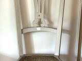 une chaise blanche avec une assise en osier, dans un coin de la pièce