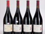 trois bouteilles de vin rouge sont alignées sur une surface blanche