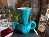 a blue vase sitting on top of a wooden table