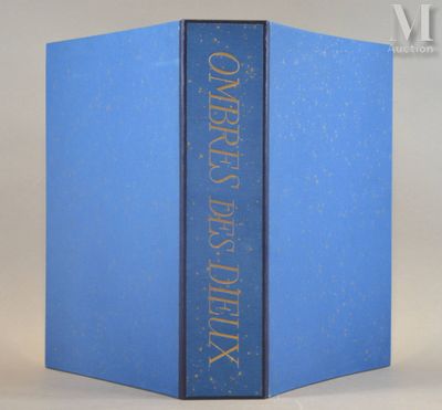 an open blue book sitting on top of a table next to a white wall