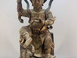 an image of a statue of a man sitting on top of a wooden block