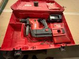 une boîte à outils rouge contenant une perceuse et d'autres outils