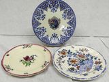 three plates with floral designs on them sitting on a table