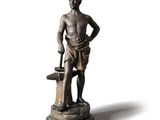 statue en bronze représentant un homme tenant un seau et un bec verseur